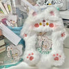 A white fluffy plush photocard holder with pink paw prints and a cute illustration inside.