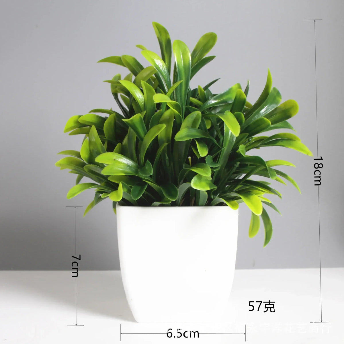 A potted artificial bonsai plant with green eucalyptus leaves in a white cylindrical pot.