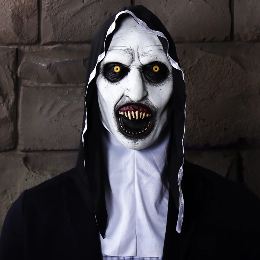 A person wearing a realistic horror nun latex mask with pale white face, dark eyes, and long black hair against a stone wall.