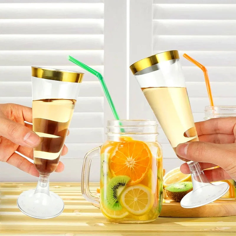 Hands hold elegant disposable champagne glasses filled with juice and garnished fruit