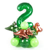 A green foil number 2 balloon surrounded by green and gold dinosaur-themed balloons.
