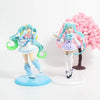 A PVC collectible figurine of Hatsune Miku in a light blue outfit with pink accents and long teal hair, standing on a circula