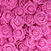 A dense cluster of artificial foam roses in various shades of pink and magenta.