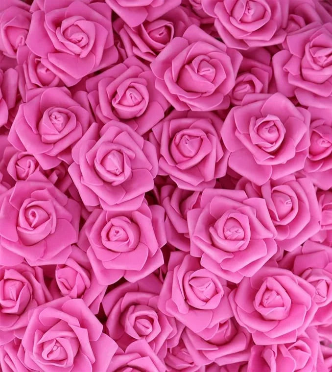 A dense cluster of artificial foam roses in various shades of pink and magenta.