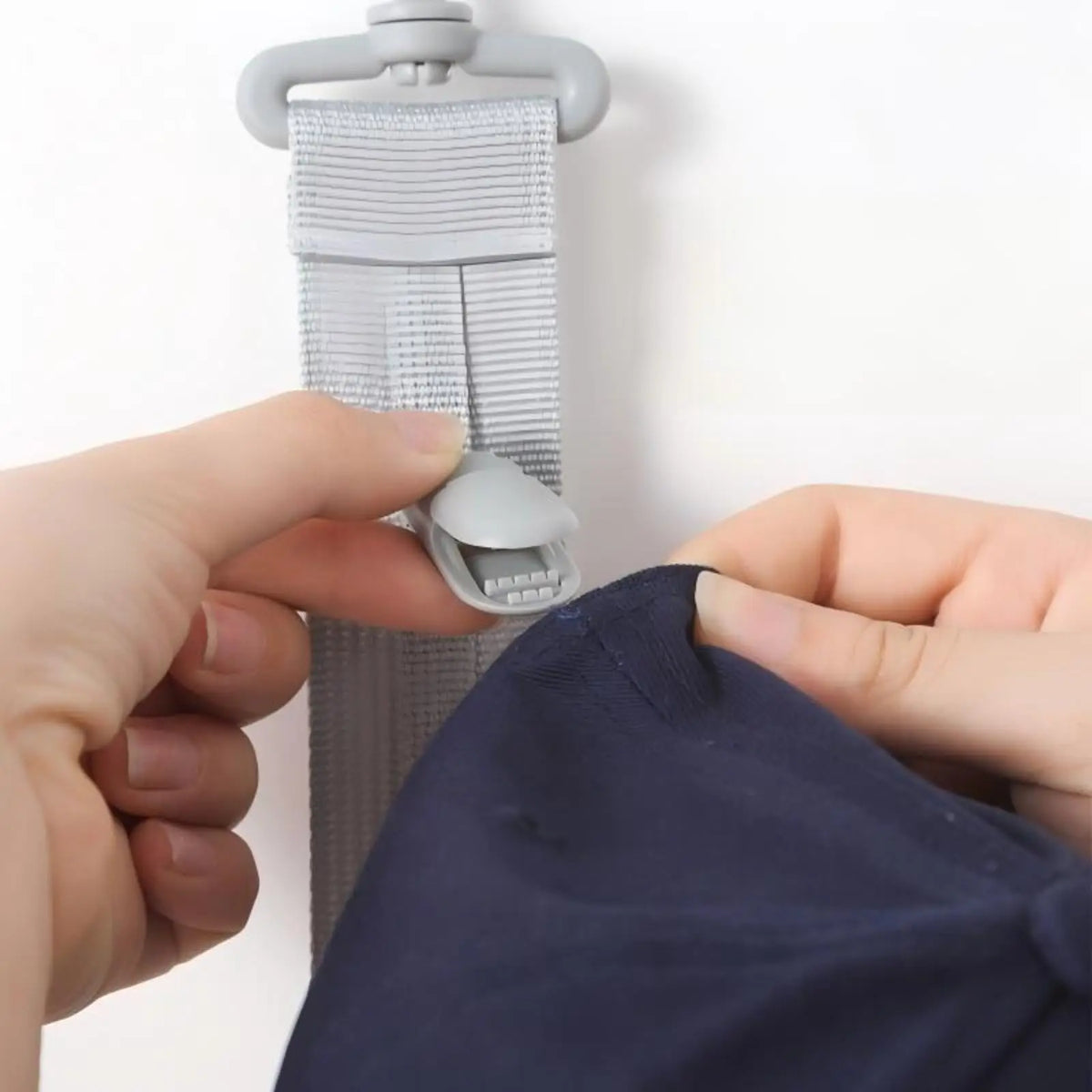 A hand is shown adjusting a multilayer hat organizer rack for closet storage.