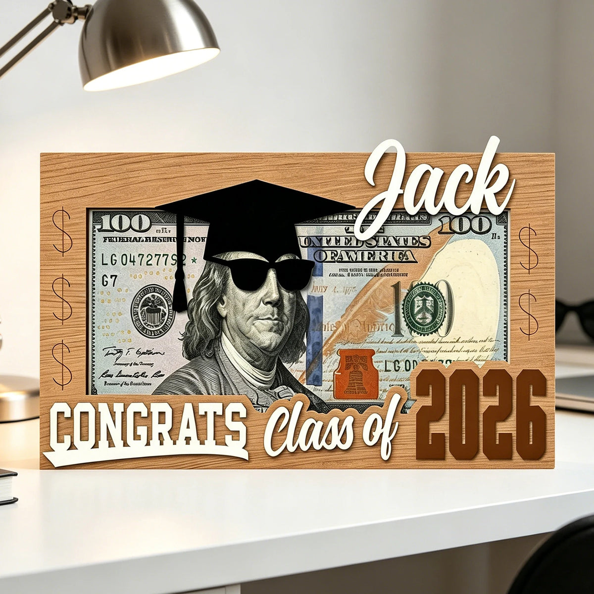 A wooden sign featuring a portrait of Jack surrounded by US currency and the text Congrats Class of 2026