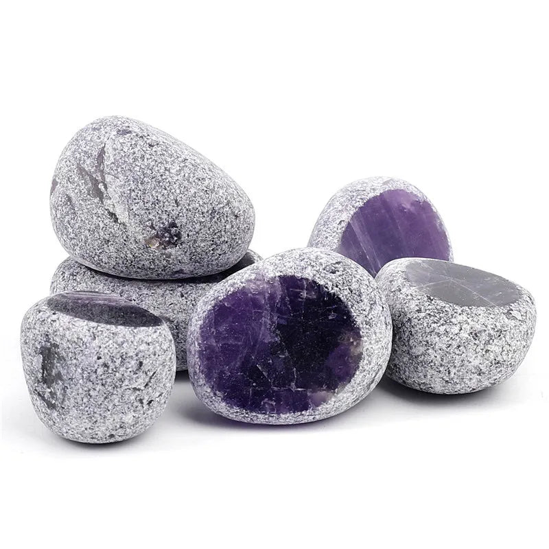 A collection of tumbled natural crystals including clear quartz, rose quartz, and amethyst stones.