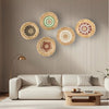 A modern living room featuring a beige sofa and several round boho straw wall hangings on the wall.