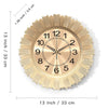 A round, rose gold wall clock with a sunburst design and Roman numerals on a white background.