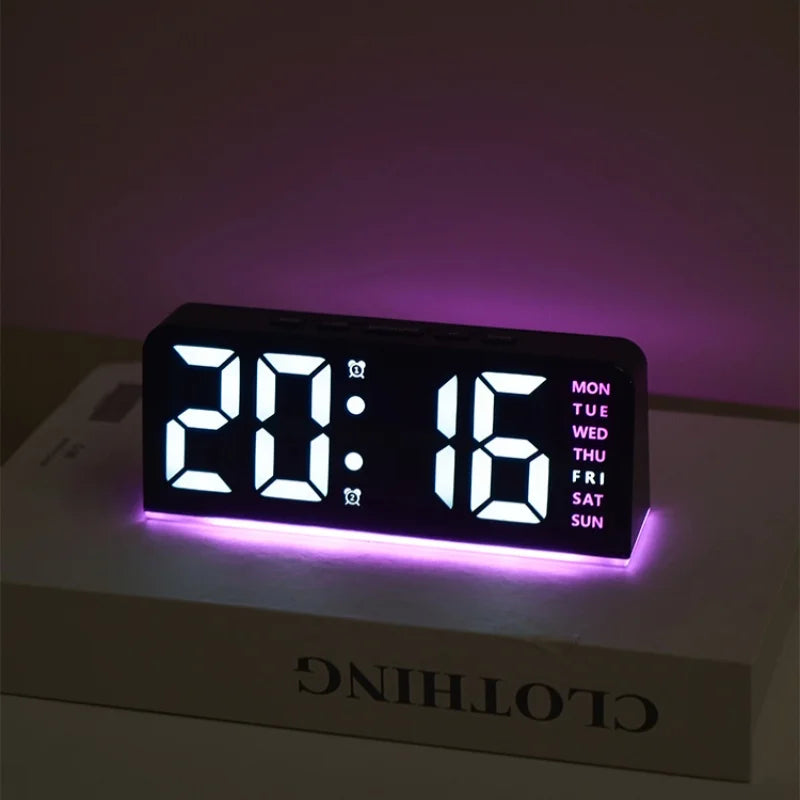 A black digital alarm clock displaying 20:16 with a purple mood light on, resting on a white box.