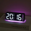 A black digital alarm clock displaying 20:16 with a purple mood light on, resting on a white box.