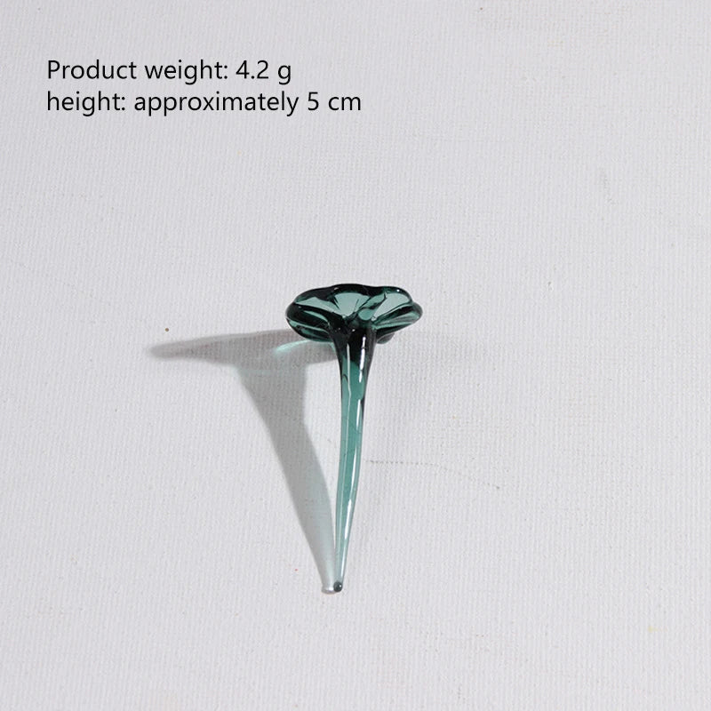 A small, teardrop-shaped glass flower with a long, slender stem, colored teal or aqua.
