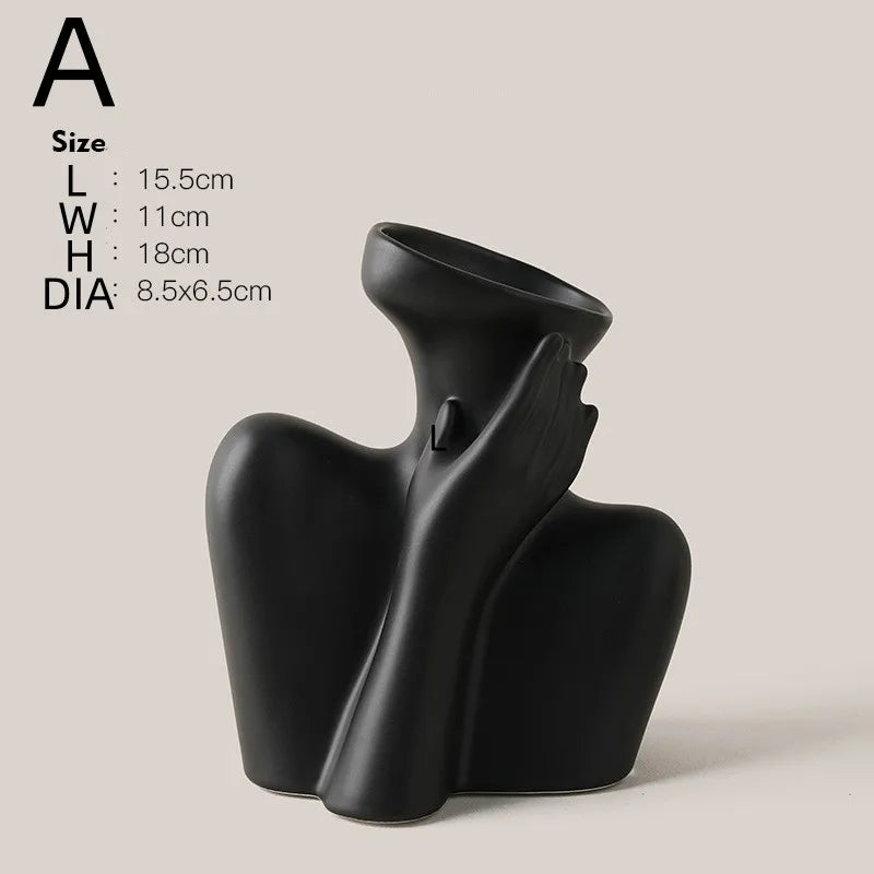 A black ceramic figural vase shaped like an artistic human hand and forearm.