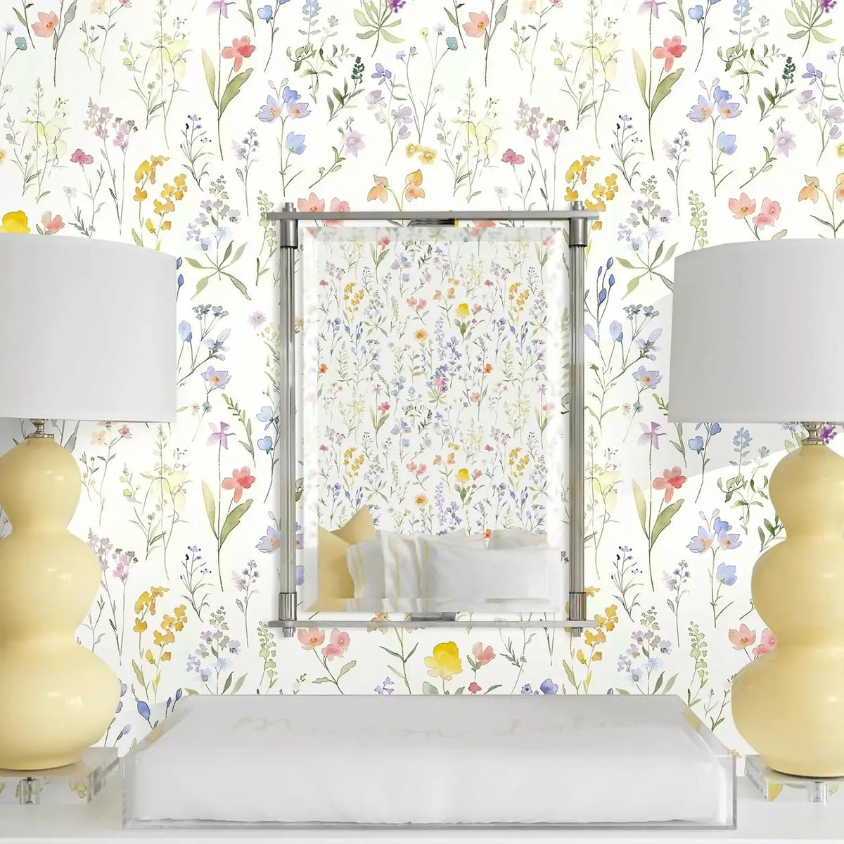 A bathroom setting featuring a mirror framed in metal and surrounded by boho floral peel and stick wallpaper.