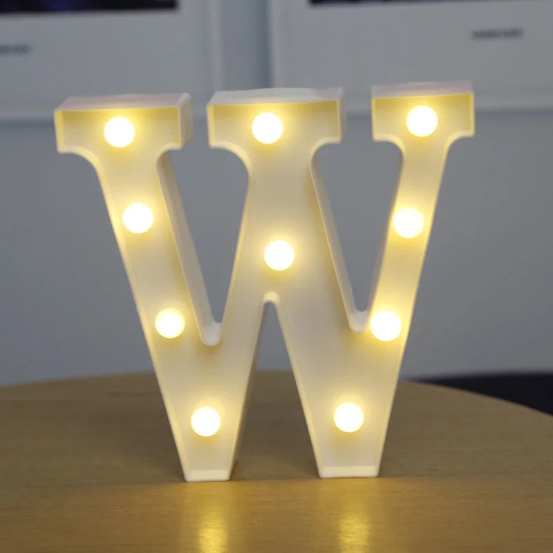 A white alphabet letter light shaped like the letter W, illuminated with warm white LEDs.