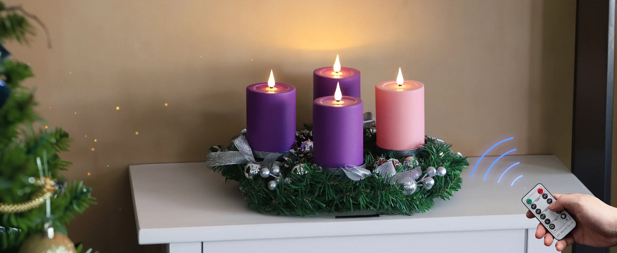 A display of purple and pink flameless LED candles arranged on a green wreath on a white table.