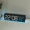 A digital LED alarm clock displaying the time 22:08 and temperature 26 degrees on a white surface.
