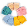 A collection of colorful, soft knee pads for crawling infants arranged in a circle.