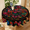 Vibrant Mexican style embroidered tablecloth featuring colorful floral and foliage patterns on a black fabric.