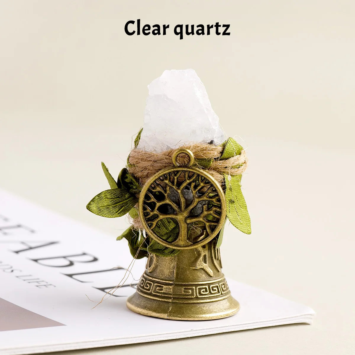 A clear quartz crystal is placed inside a natural brass bell with a copper finish.