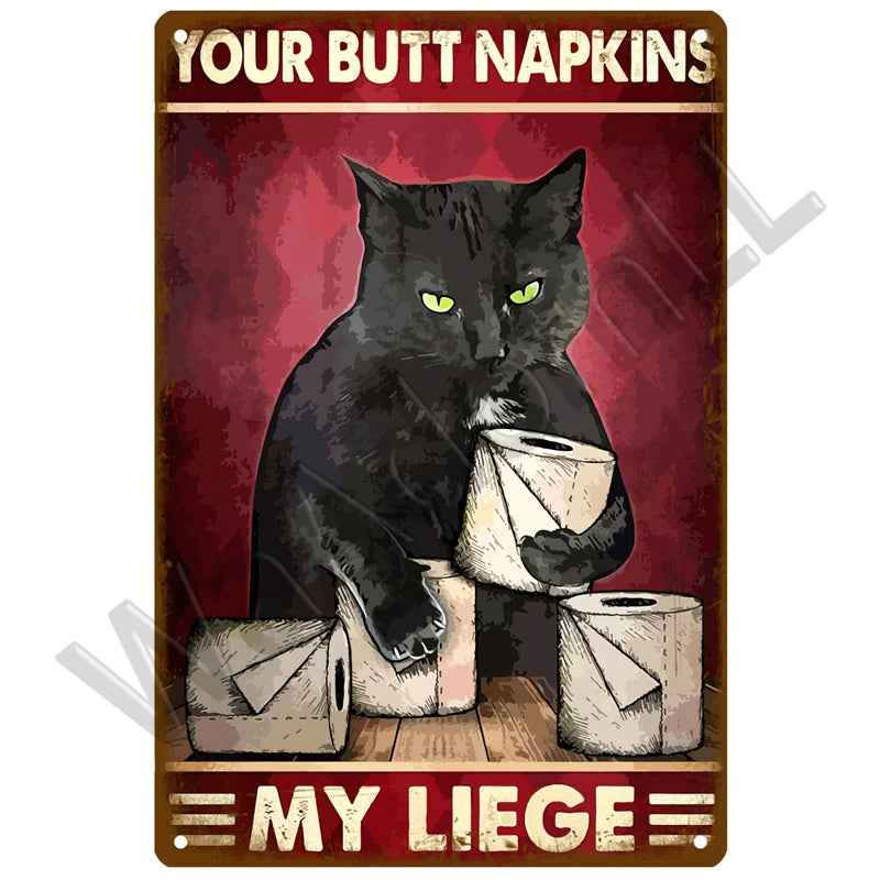 A black cat is sitting next to a roll of tissue paper on a vintage metal sign that reads Your Butt Napkins My Liege.