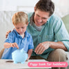 A father is showing a toddler how to use a blue piggy bank for coin storage.