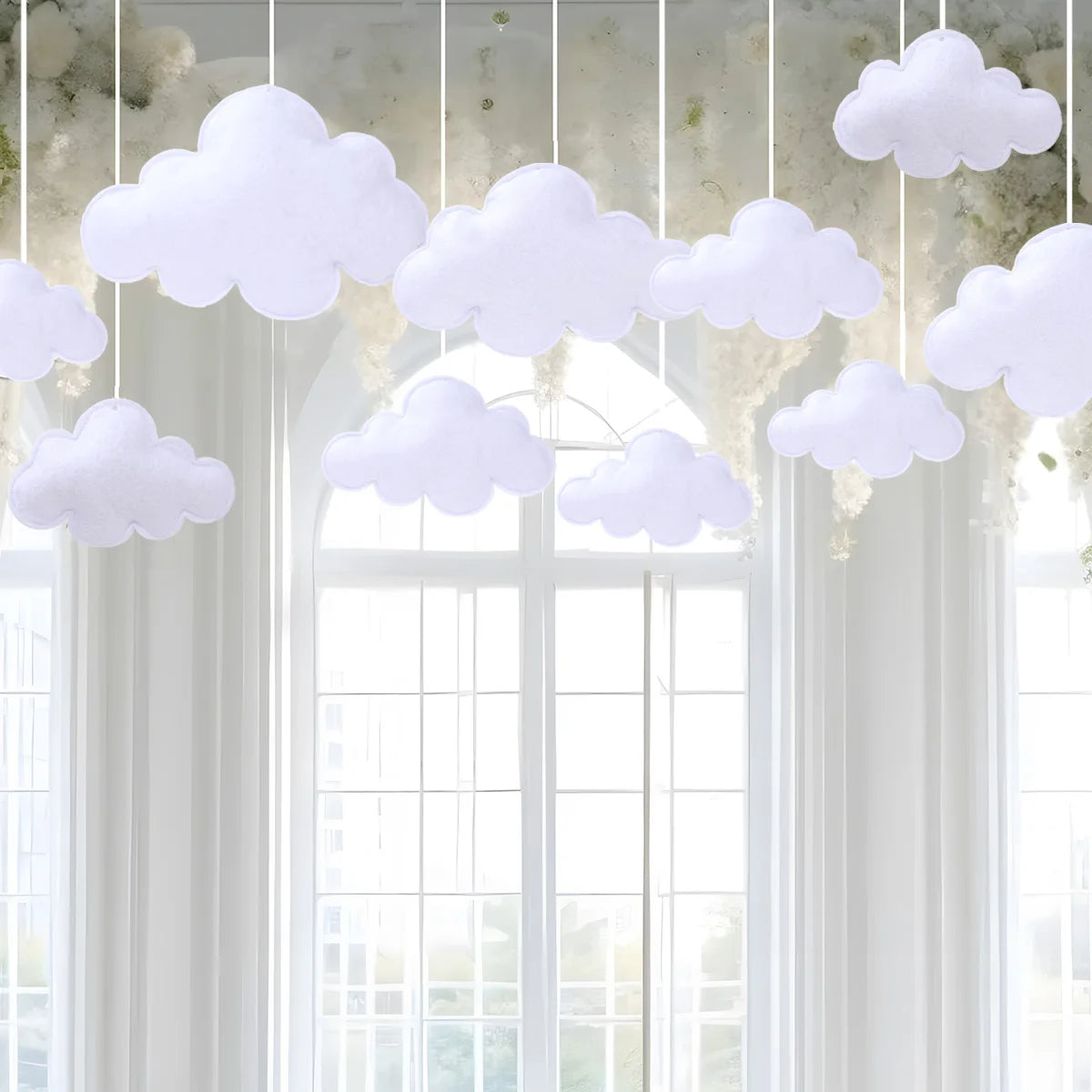 White cloud felt hanging decorations suspended in a window frame