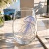 A clear wine glass filled with water features a handcrafted blue-ringed octopus decoration.