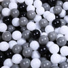 A close-up view of a large pack of colorful, glossy plastic balls in various shades of black, white, and gray.