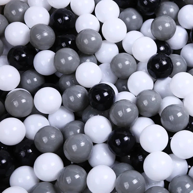 A close-up view of a large pack of colorful, glossy plastic balls in various shades of black, white, and gray.