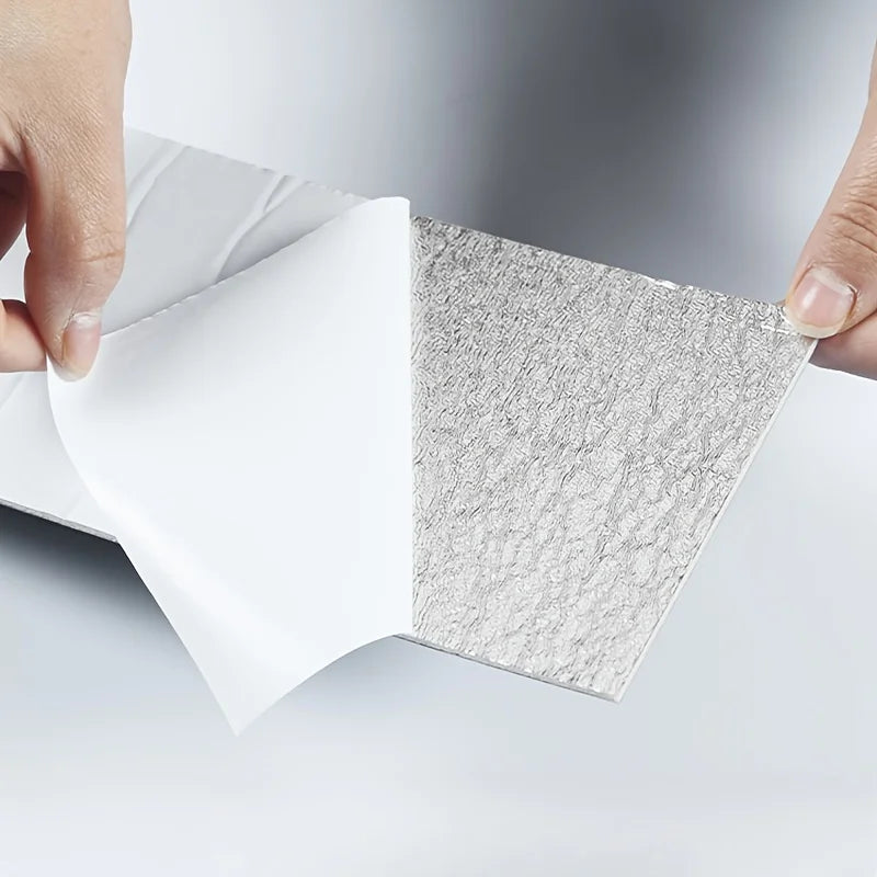A hand is peeling back a sheet of self-adhesive PVC baseboard trim featuring a textured brick pattern.
