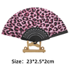 A folding hand fan featuring a leopard print design on the fabric and a black handle.
