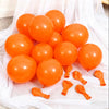 A cluster of bright orange latex balloons scattered on white sheer fabric.
