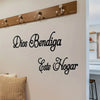 Dekoratives Wanddekal mit dem Text Dios Bendiga Este Hogar an einer weißen Wand über einem Holzpfosten.