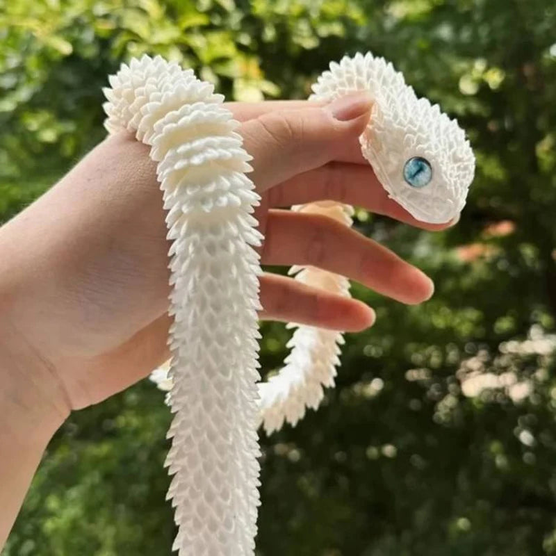 Eine Hand hält ein weißes, strukturiertes 3D-gedrucktes Schlangen-Fidget-Spielzeug mit einem blauen Auge.