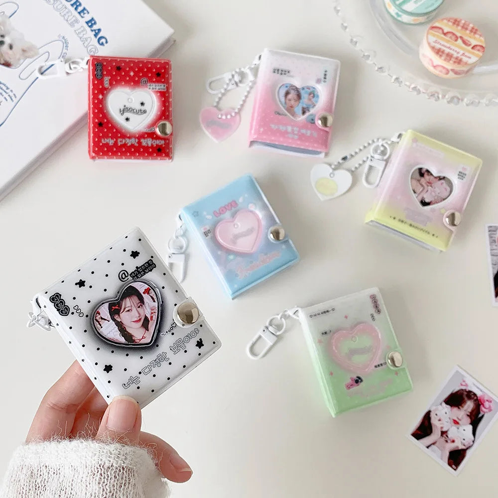 A collection of pink and clear photo album keychains featuring cartoon hearts and various designs.