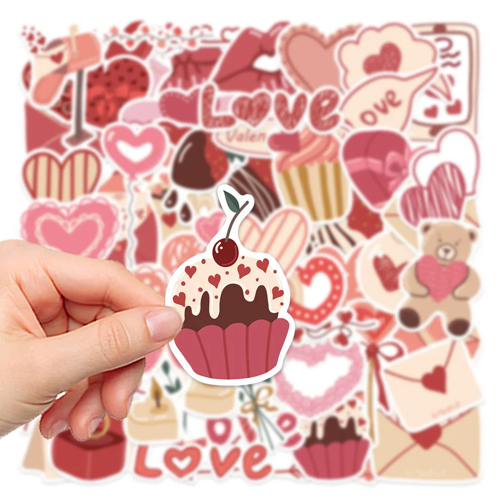 A hand holds a sheet of pink and red love-themed decorative stickers featuring hearts, cupcakes, and other sweet designs.