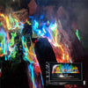 A display of magic fire with vibrant colors like green, blue, and orange flames erupting from dark wood.