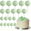 A set of twenty light green mini foam ball cake toppers on white sticks.
