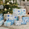 Scène festive de Noël avec un sapin décoré et des cadeaux emballés sous la neige