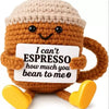 A handmade crochet potato doll made of brown yarn holding a card that reads I can't espresso how much you bean to me
