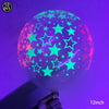 A translucent latex balloon filled with neon glow-in-the-dark stars and shapes against a purple background.