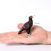 A dark brown owl figurine is shown resting on the palm of a hand, with measurements indicating its size.