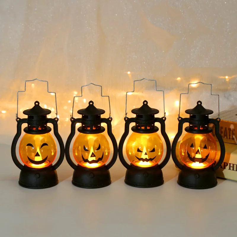 Four black hanging lanterns shaped like carved pumpkins with glowing orange light