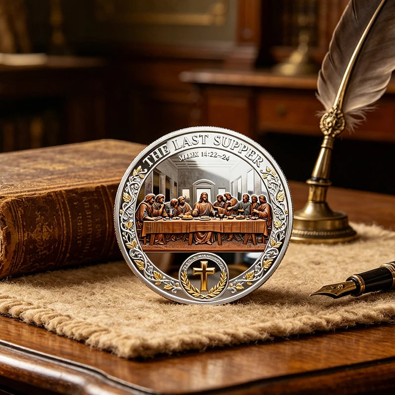A commemorative coin set featuring the Last Supper scene and a cross design resting on a wooden surface.