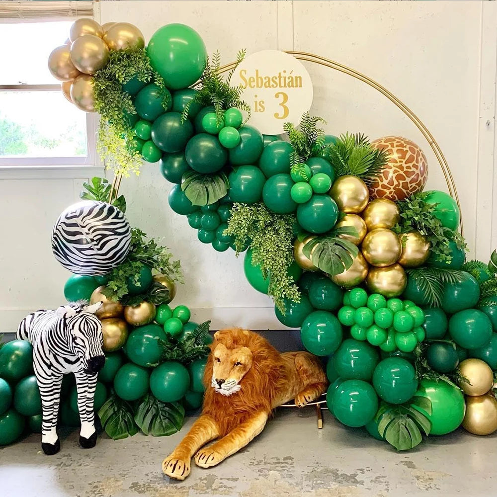 A lush green balloon arrangement featuring jungle foliage and a lion statue for party decor