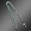 A necklace featuring a vintage cross and Virgin Mary pendant made of small, pale green pearls.