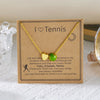 Gold tennis necklace with a heart pendant on a kraft paper card.