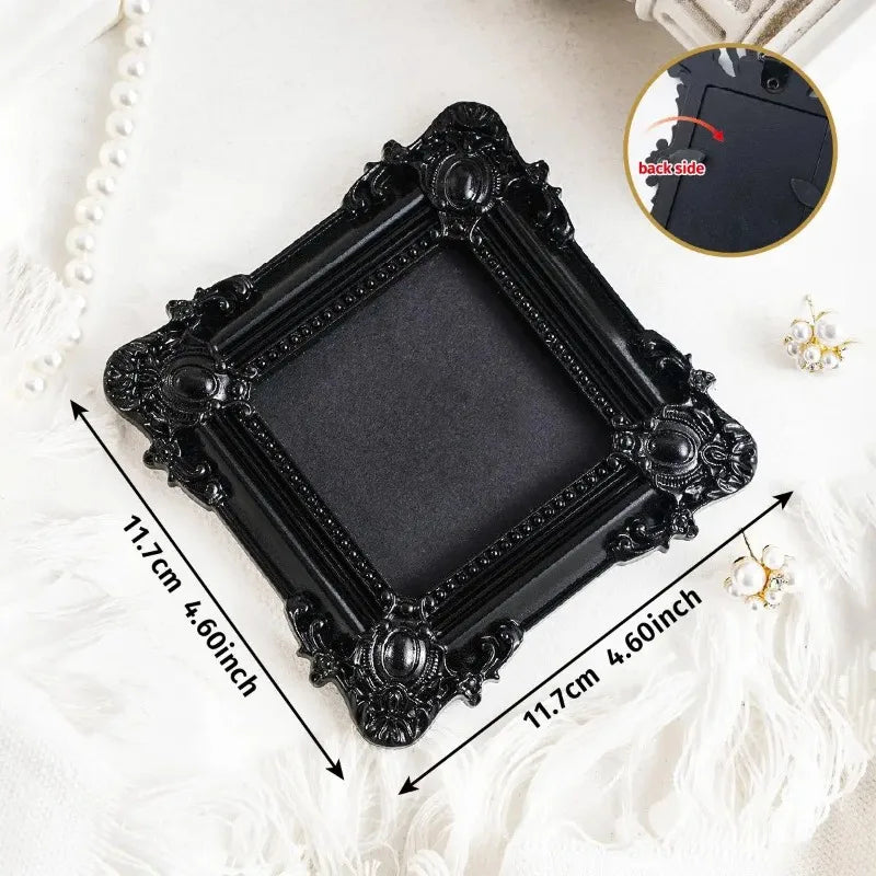 Black vintage resin mini picture frame with ornate detailing displayed on a white surface.