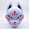 A white fox face mask with black eyes and red markings, designed for Halloween or costume parties.